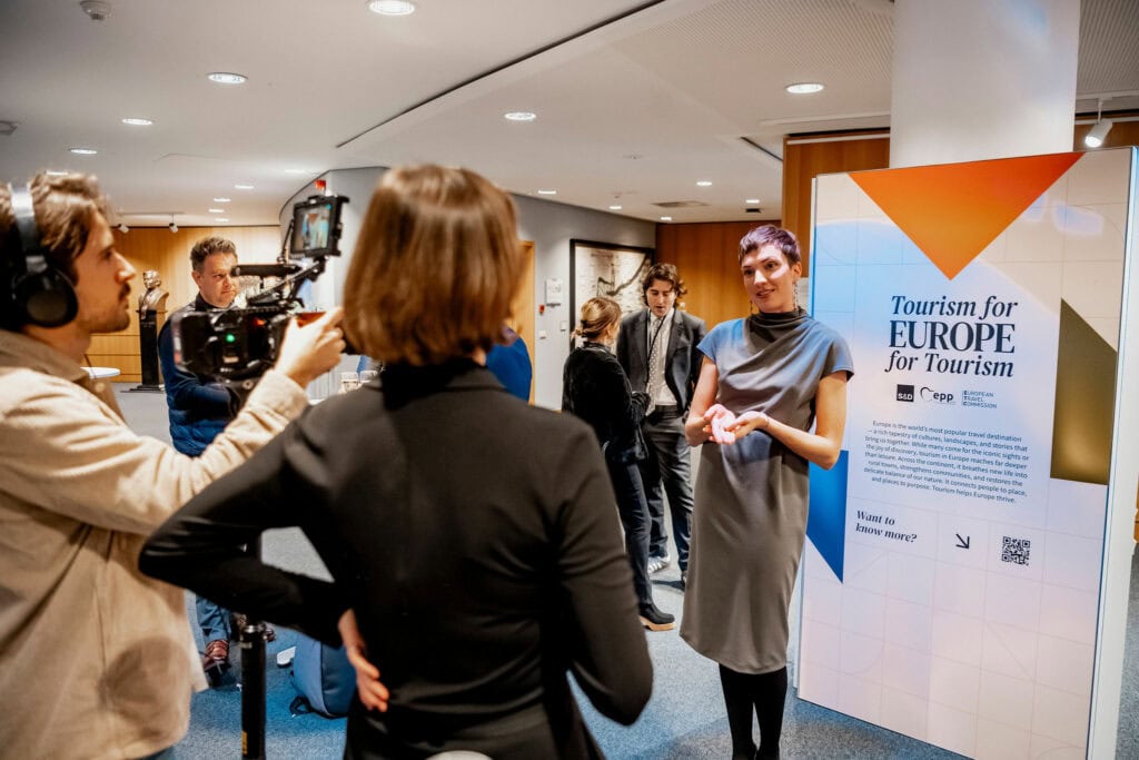 Woman being interviewed at EU-turn tourism event in Europe.